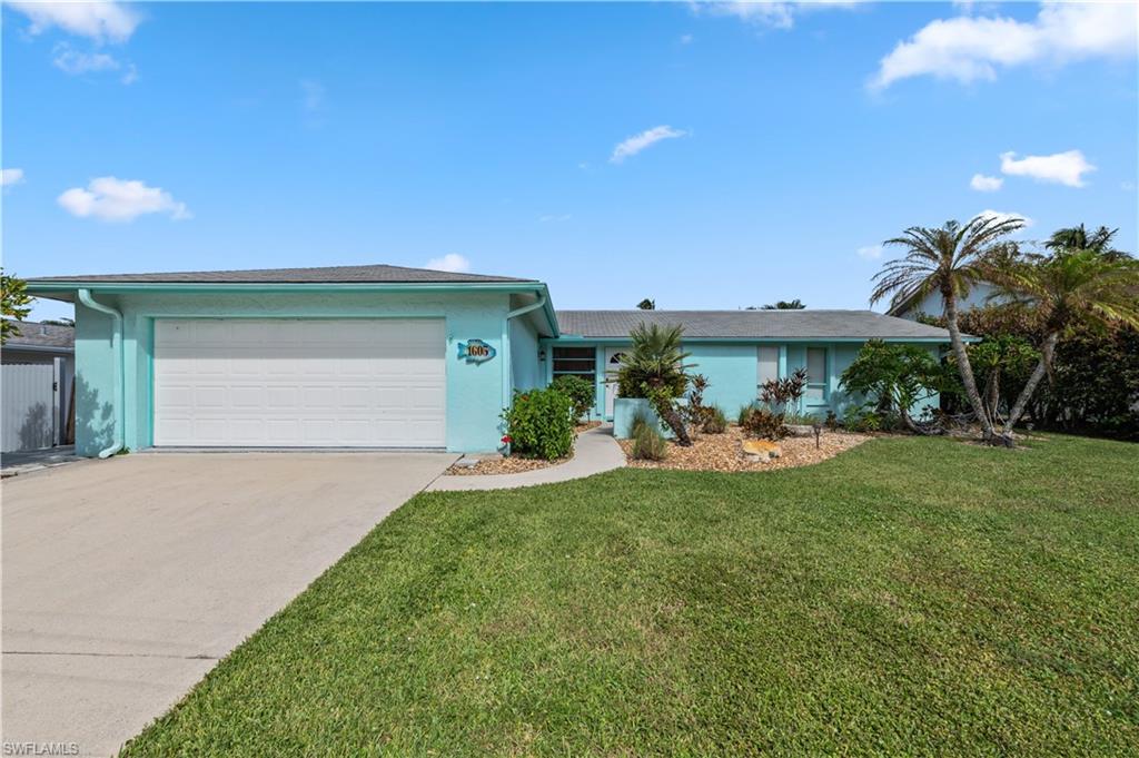 Ranch-style home with a front lawn and a garage