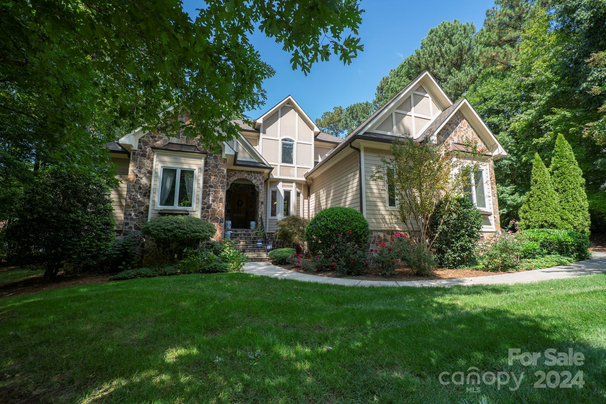 a front view of a house with a yard and trees