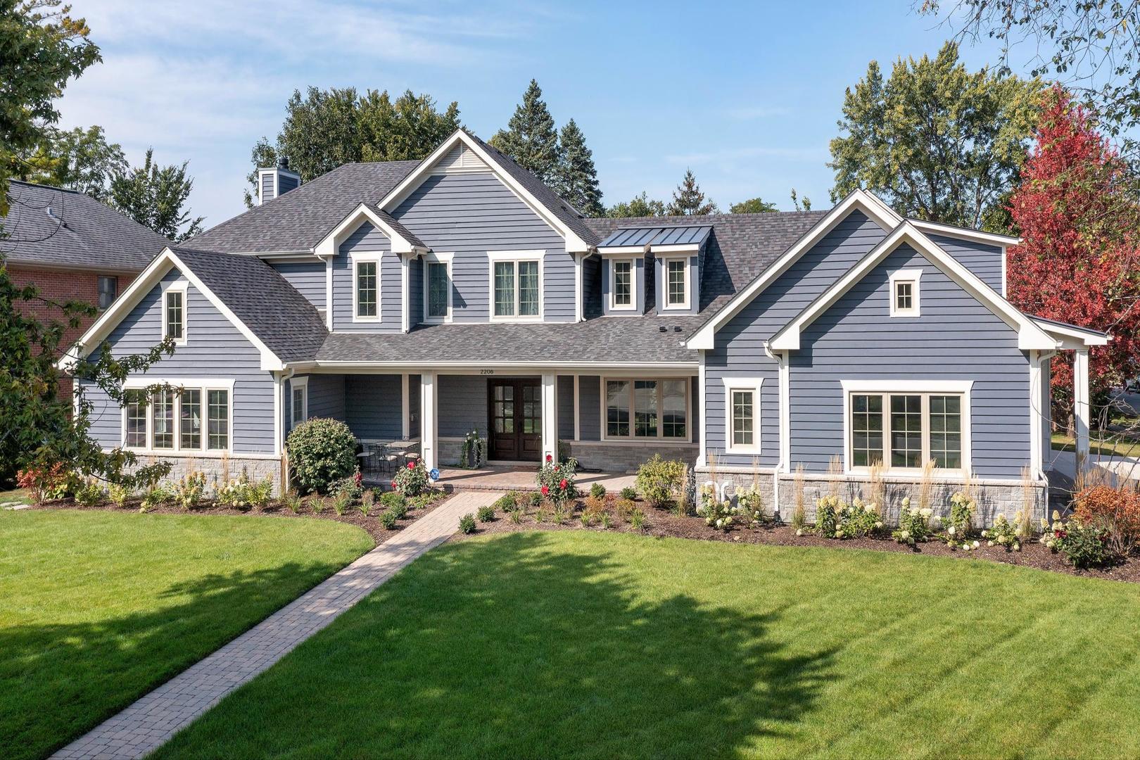 a front view of a house with a yard and trees