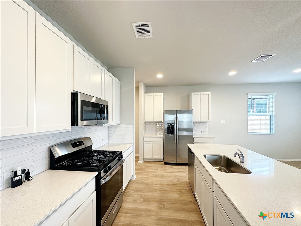 a kitchen with a stove a sink and a microwave