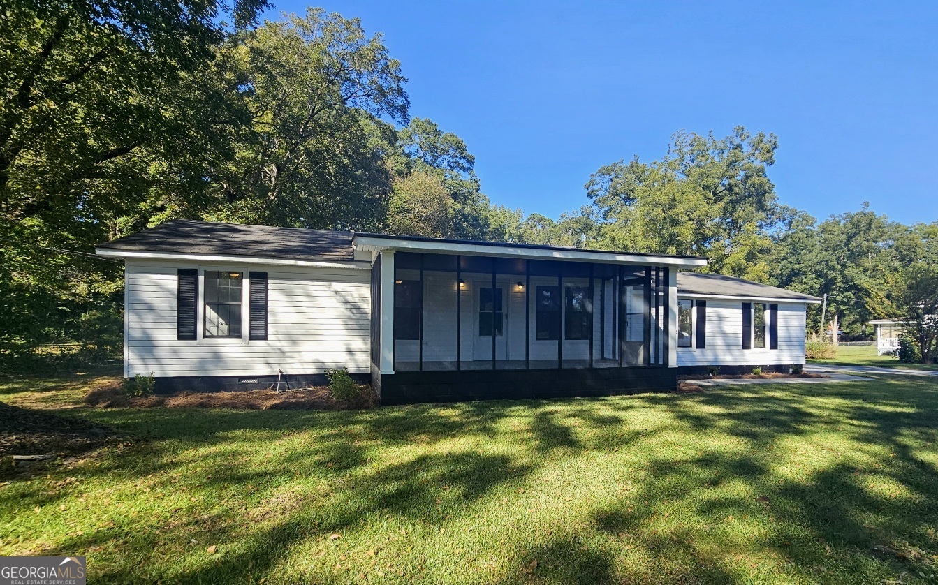 a front view of house with yard and trees in the background