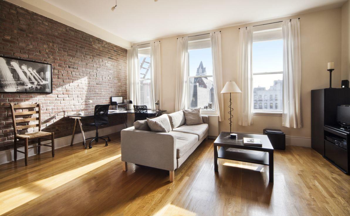 a living room with furniture wooden floor and a flat screen tv