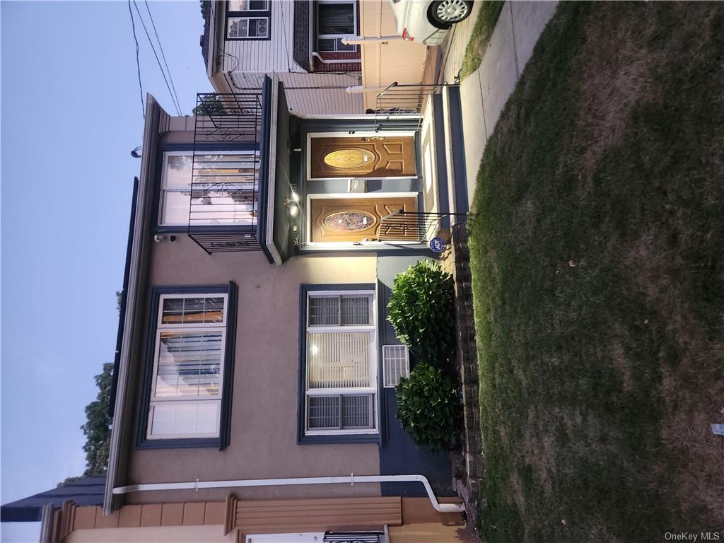 View of front of house with a yard and a balcony