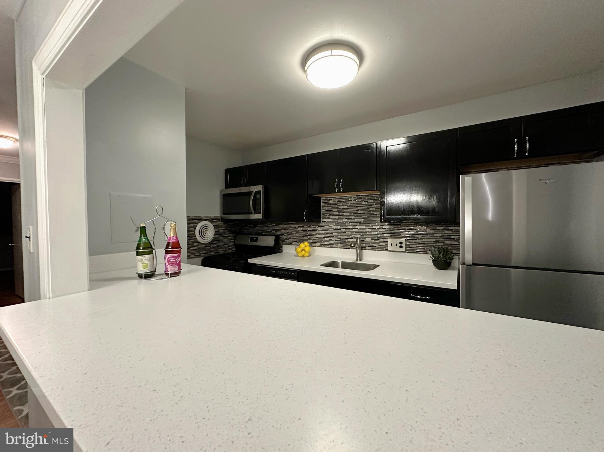 a kitchen with a refrigerator and a stove top oven