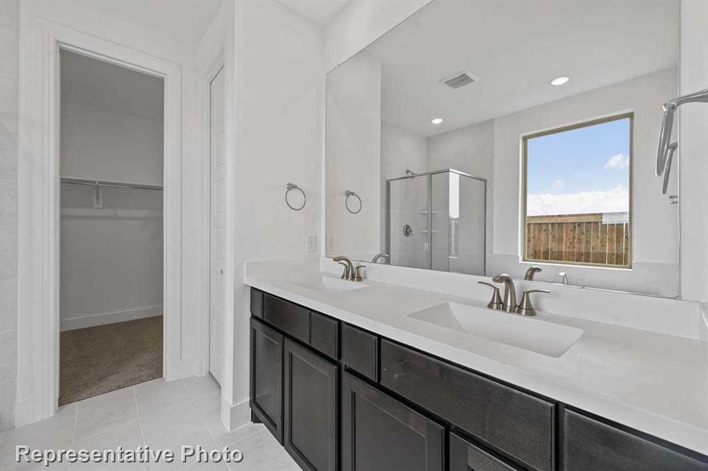 a bathroom with a double vanity sink a mirror and a shower