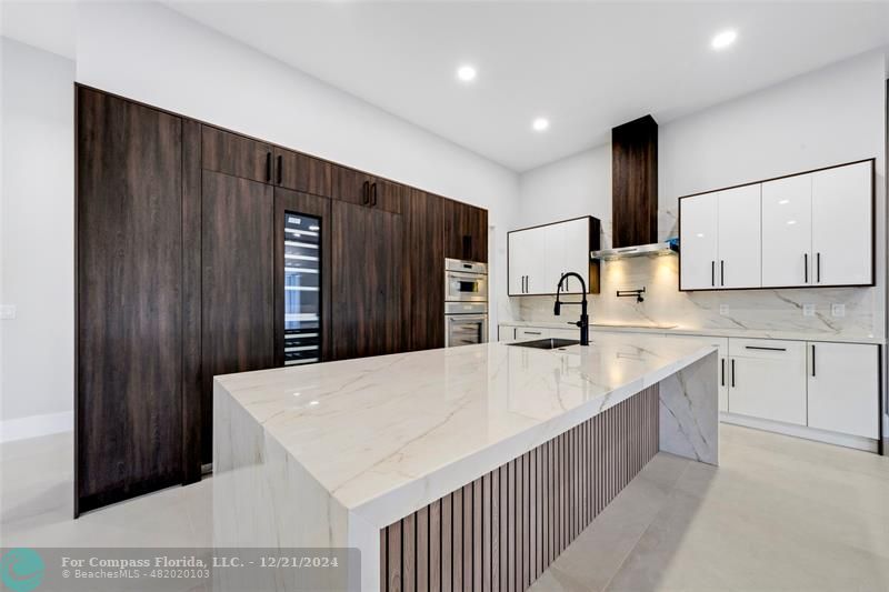 a large kitchen with stainless steel appliances a large counter top