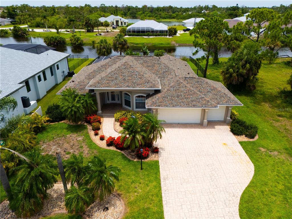 an aerial view of a house with a yard and lake view