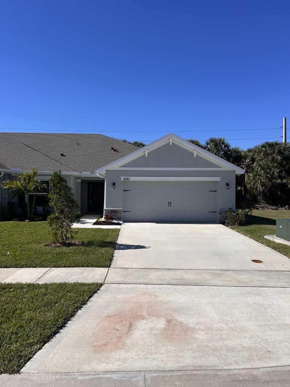 a front view of a house with a garden and yard