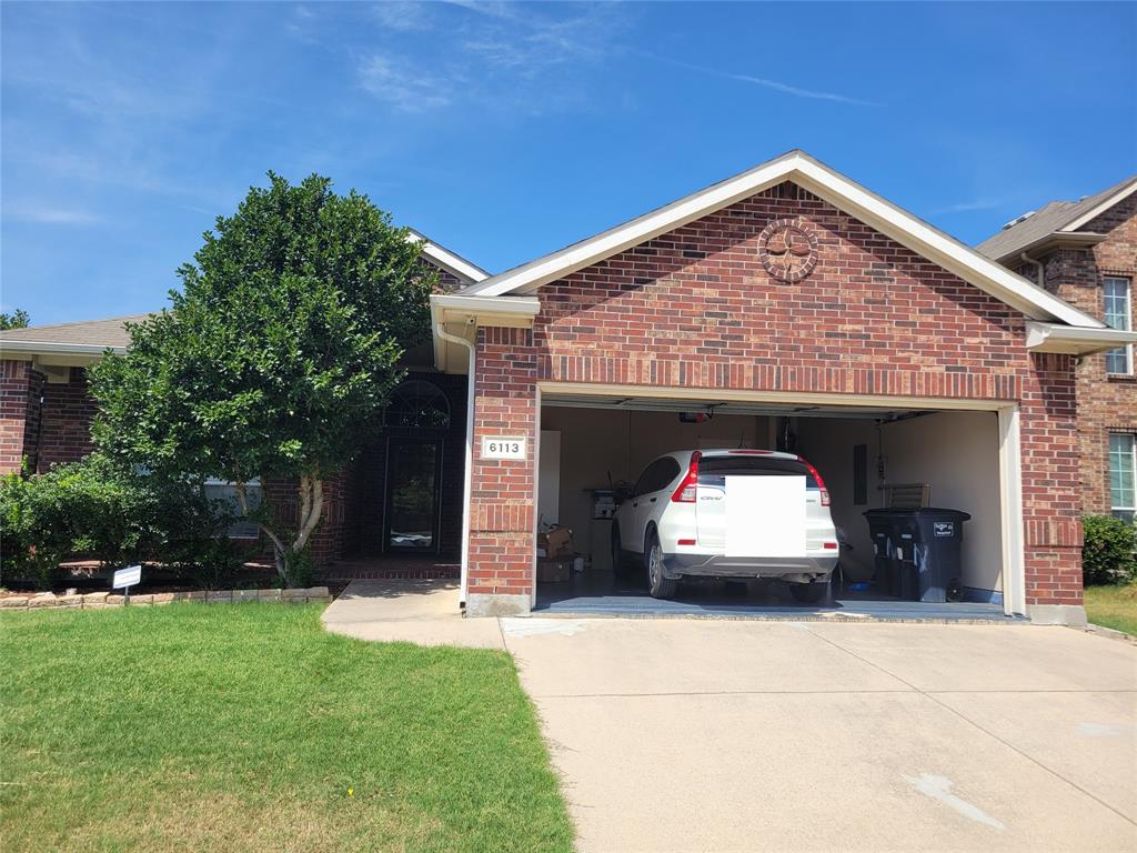 a view of a car parked in front of a house with a small yard