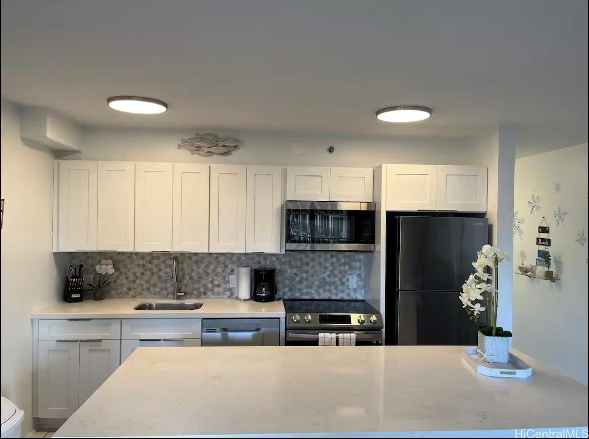 a kitchen with stainless steel appliances a refrigerator sink stove and microwave