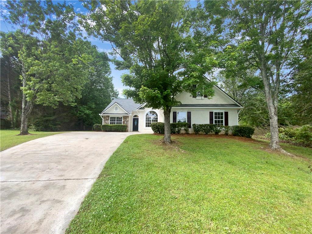 a front view of a house with a yard and trees