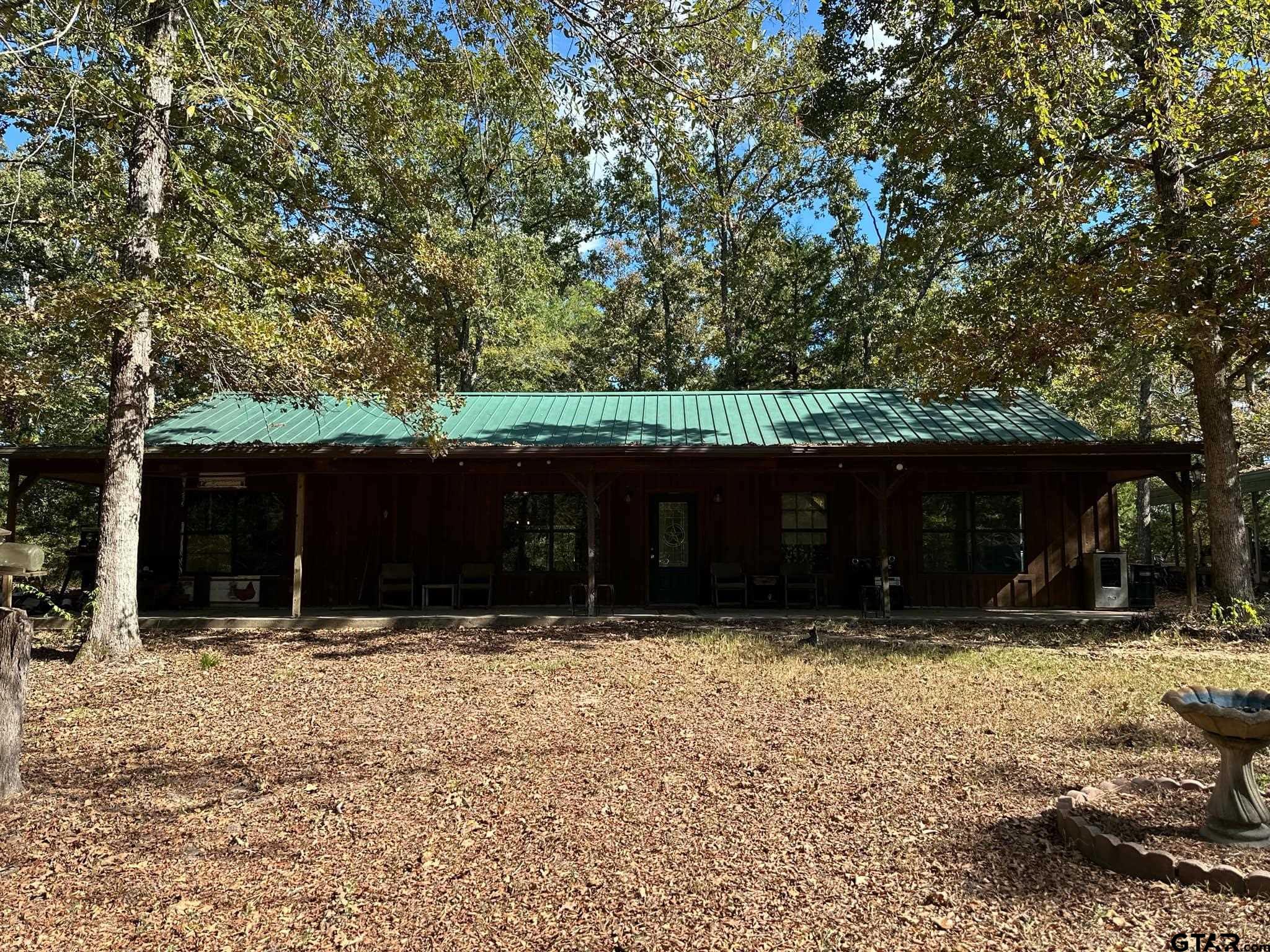 a front view of house with yard and trees in the background