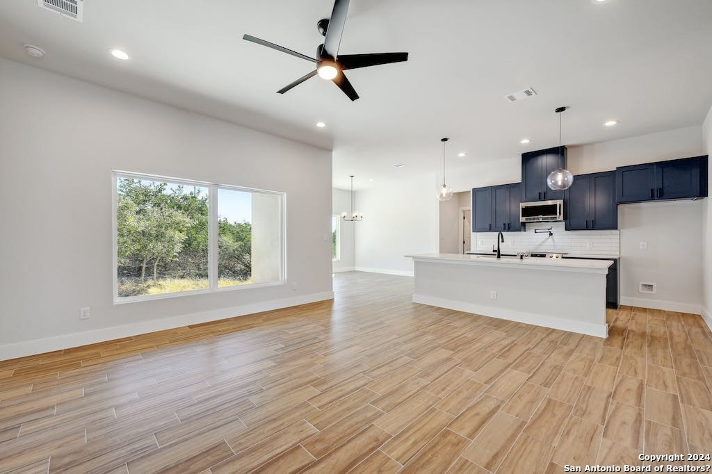 a view of kitchen with stainless steel appliances kitchen island a sink and wooden floor