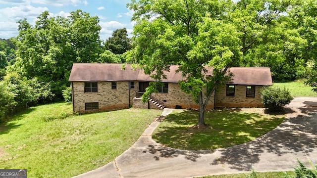 a view of a house with backyard and sitting area