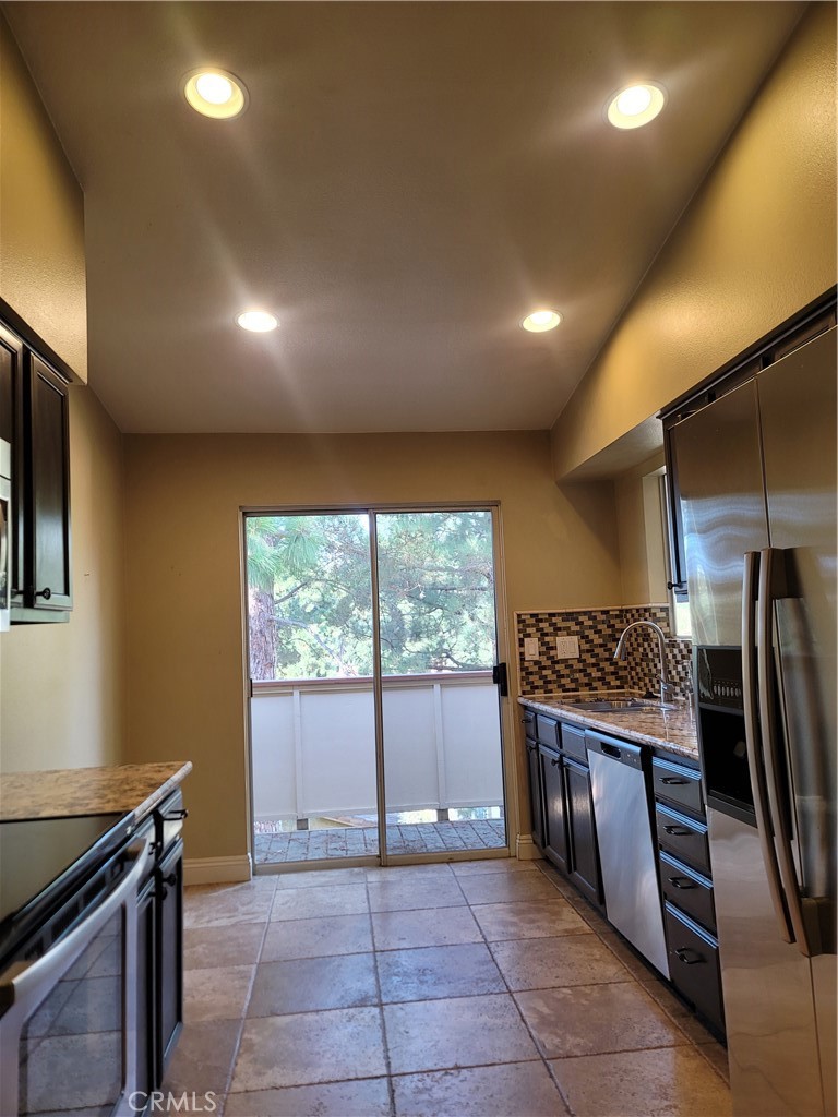 a kitchen with stainless steel appliances granite countertop a refrigerator and a stove