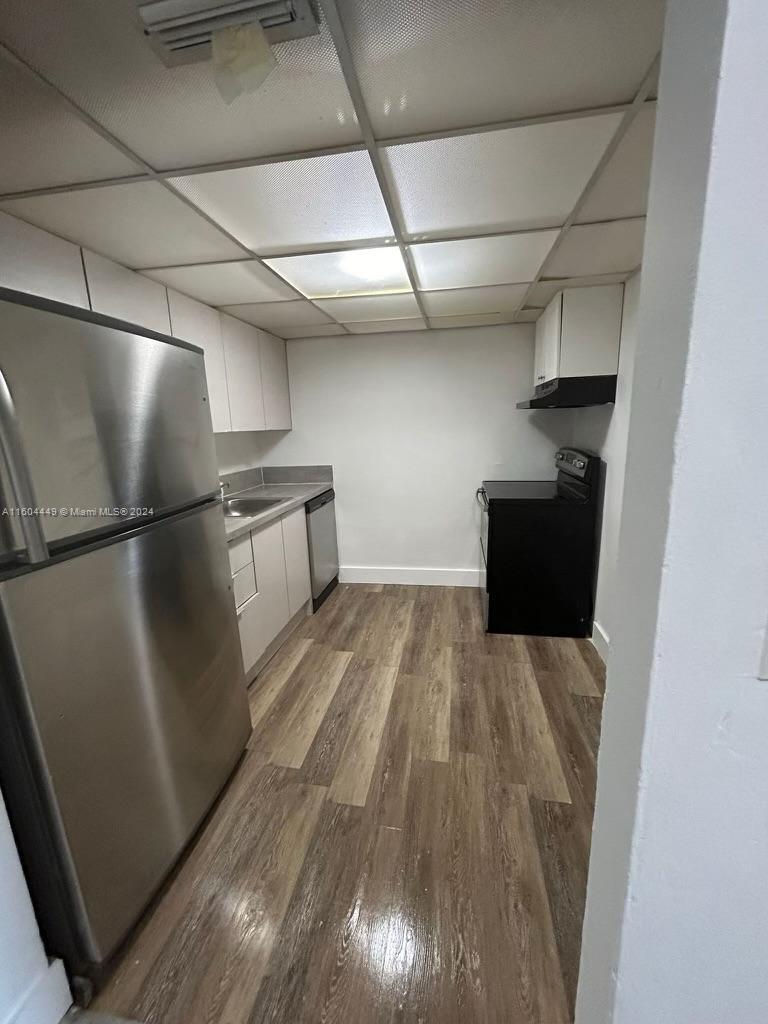 a view of a walk in closet with wooden floor