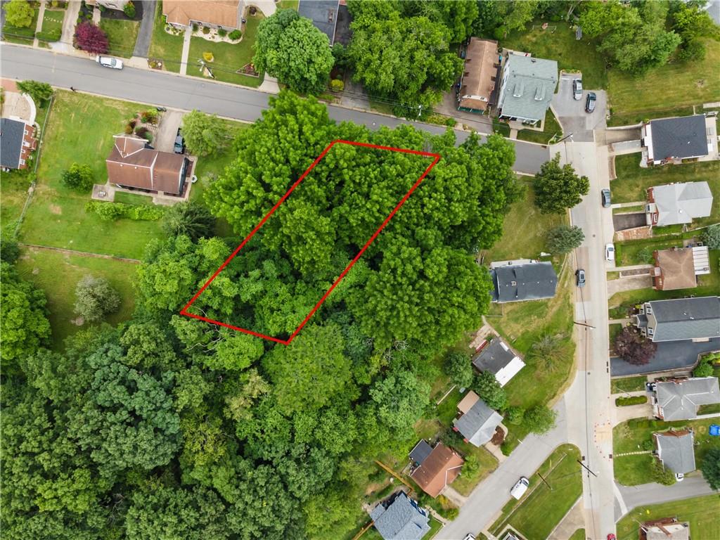 an aerial view of residential house with outdoor space and trees all around