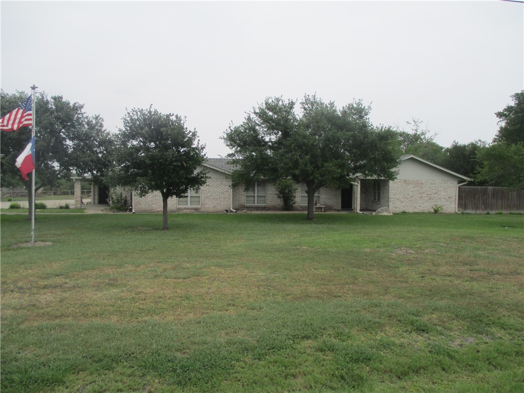 a view of a house with backyard and tree