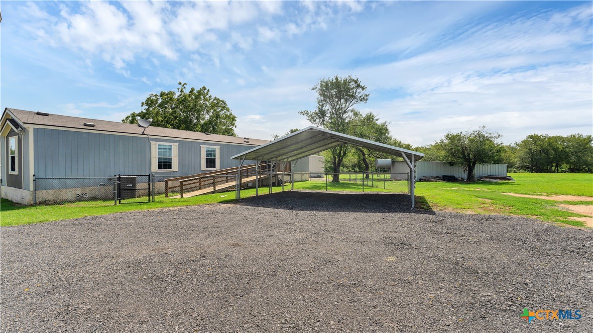 a view of a house with a yard and a large tree