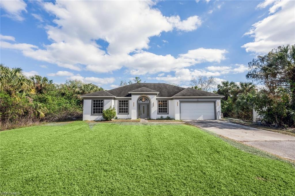 Single story home featuring a front yard and a garage