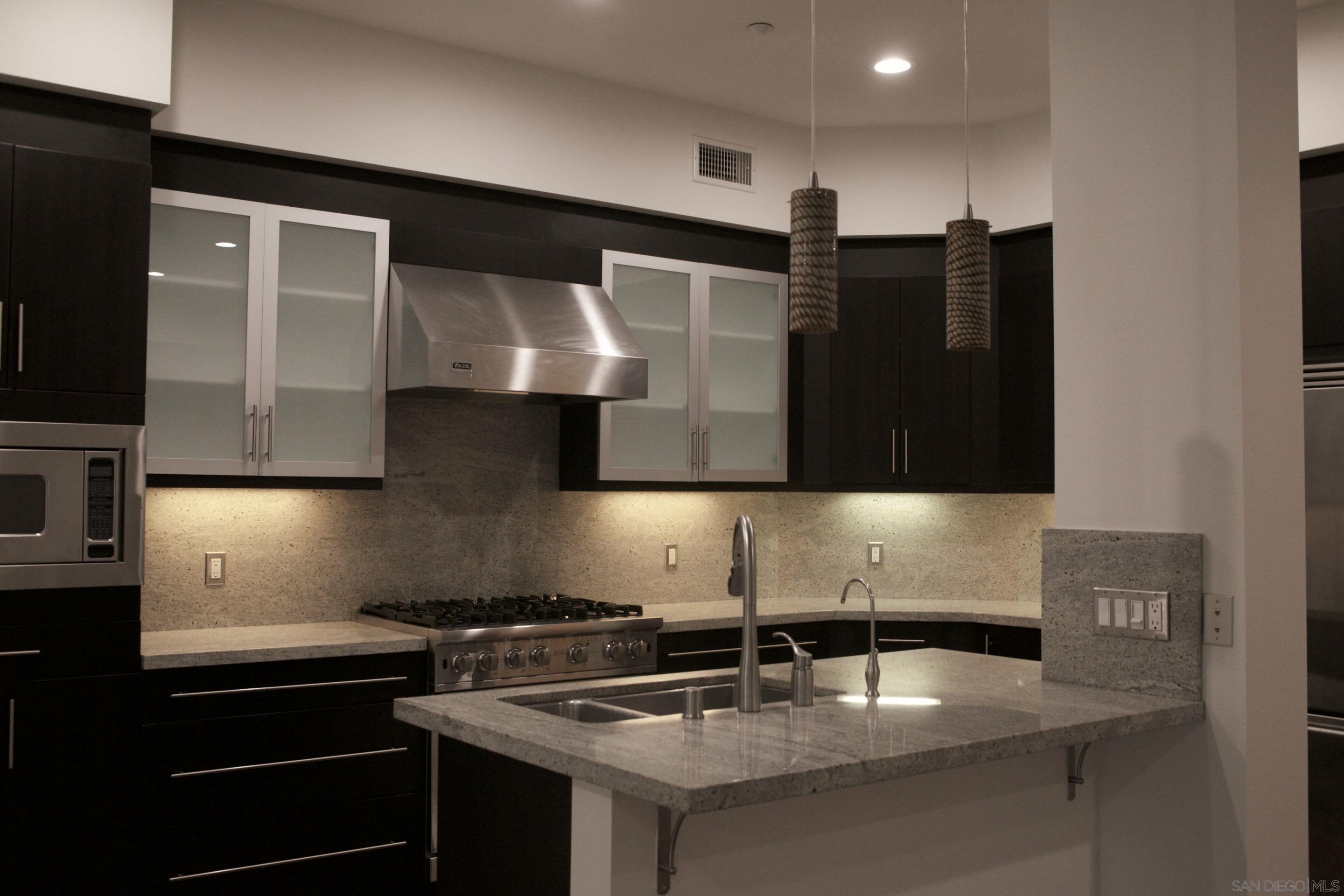 a kitchen with stainless steel appliances granite countertop a sink and a stove