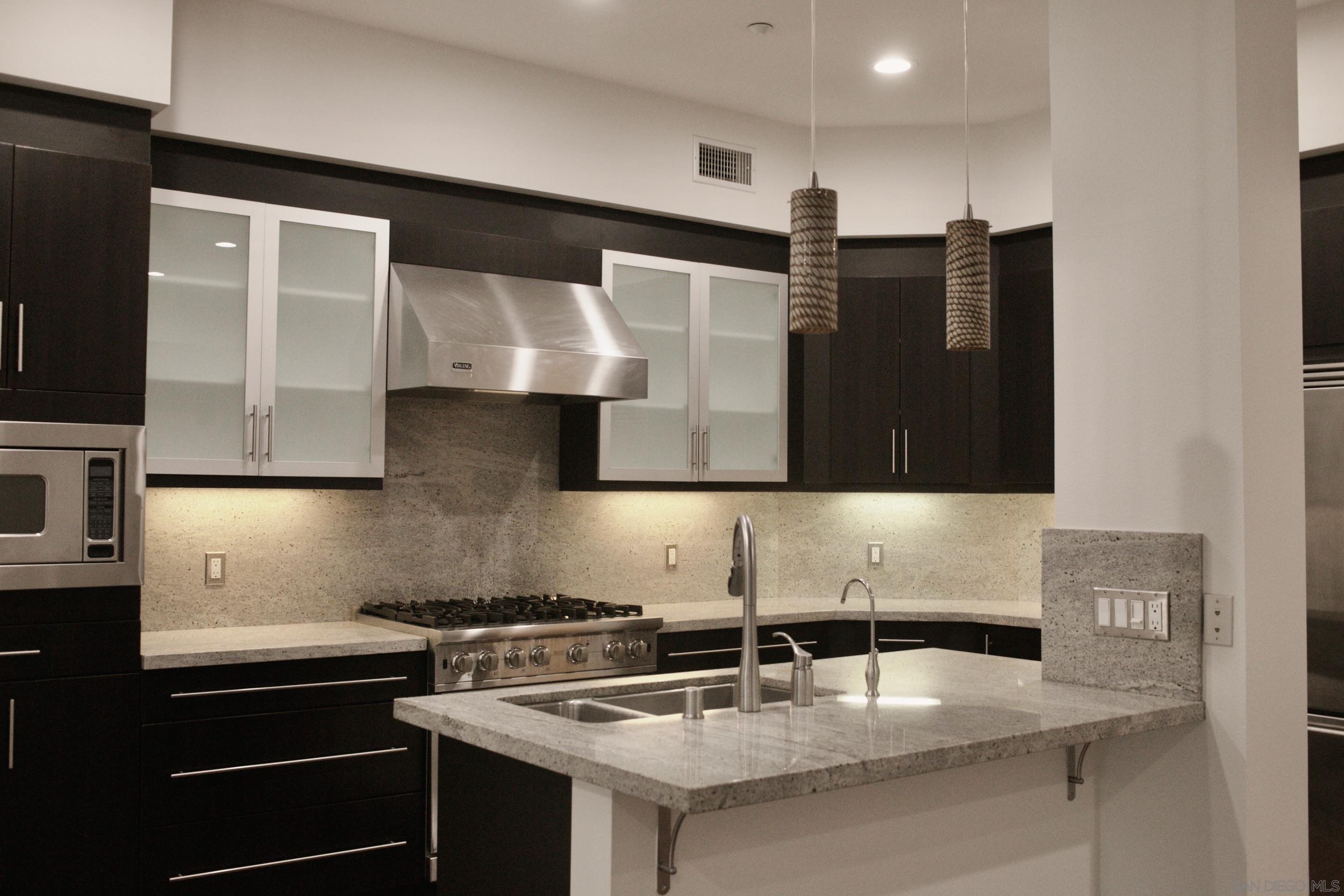 a kitchen with stainless steel appliances granite countertop a sink and a stove