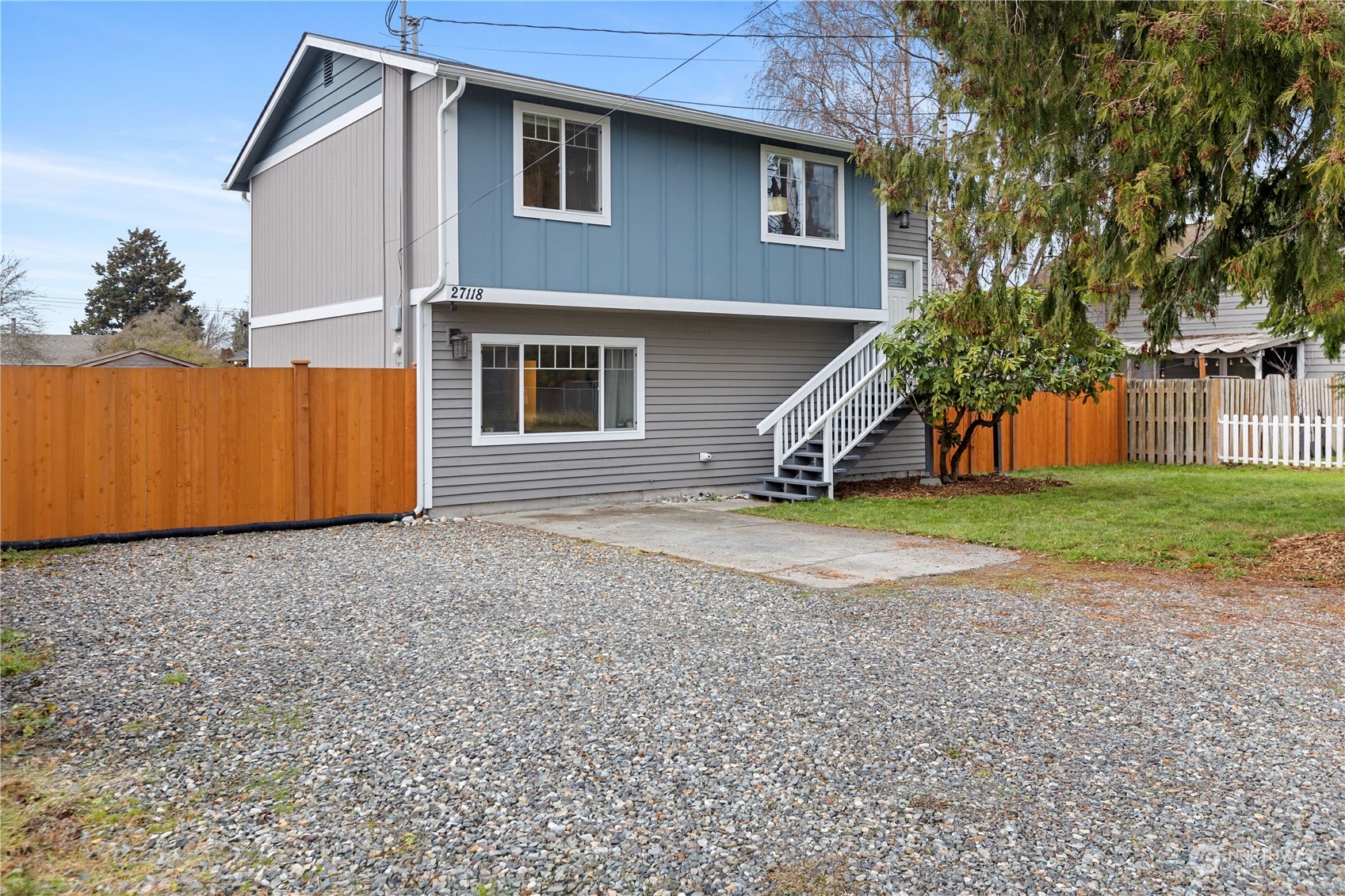 a view of a house with a yard and wooden fence