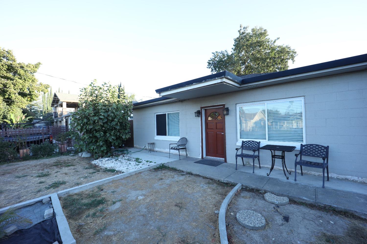 a view of a house with backyard sitting area and garden