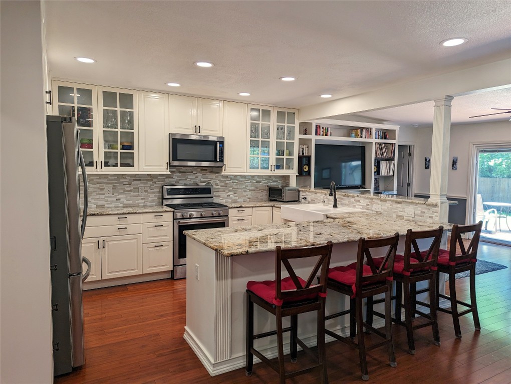 a kitchen with stainless steel appliances kitchen island granite countertop a stove a sink and a microwave