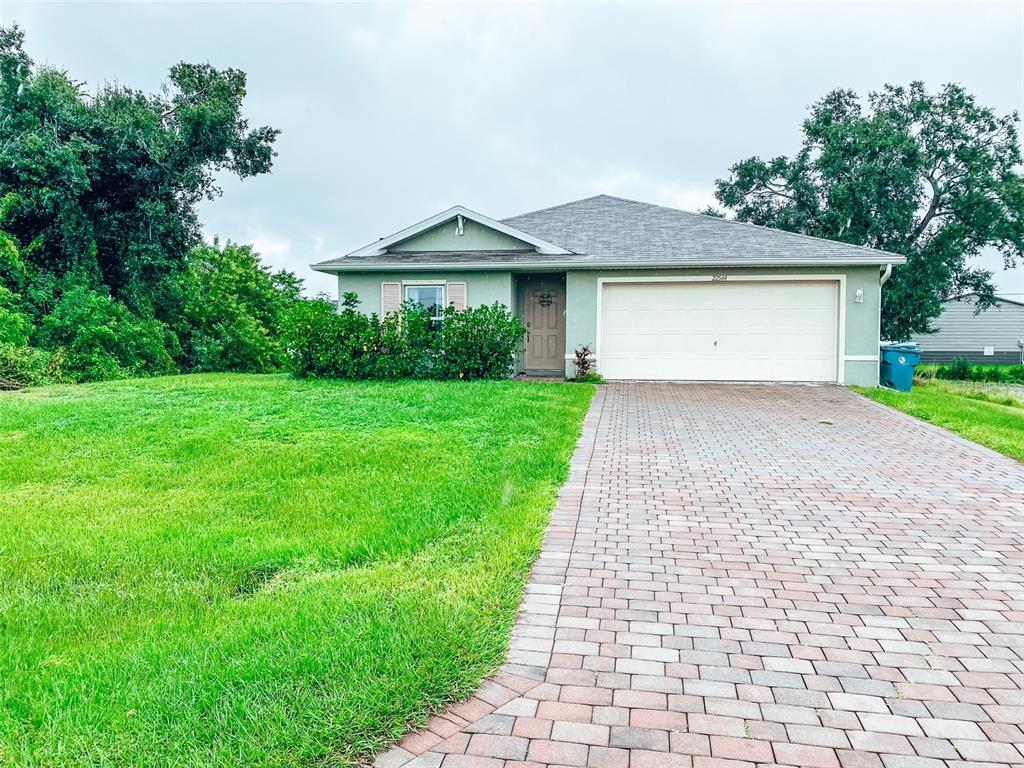 a front view of a house with a yard and trees