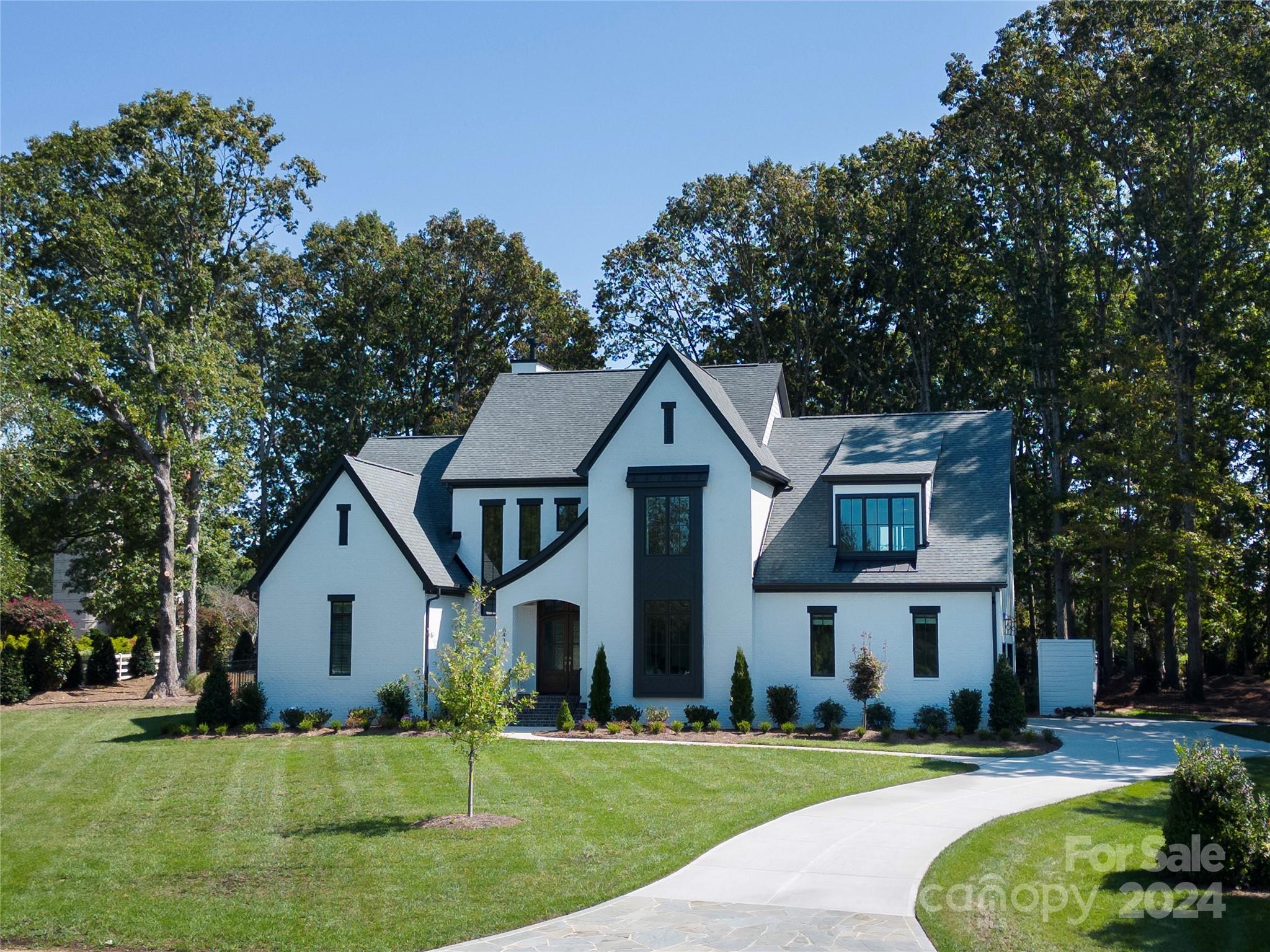 a front view of a house with a yard and trees