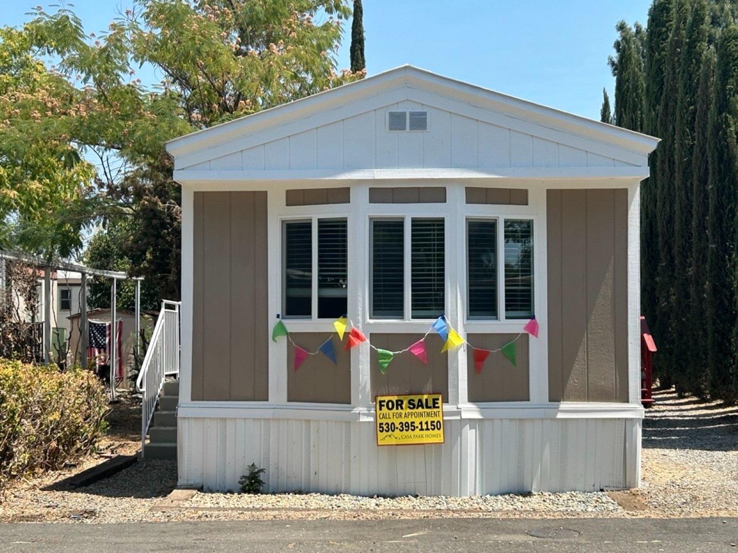 a front view of a house with a tree