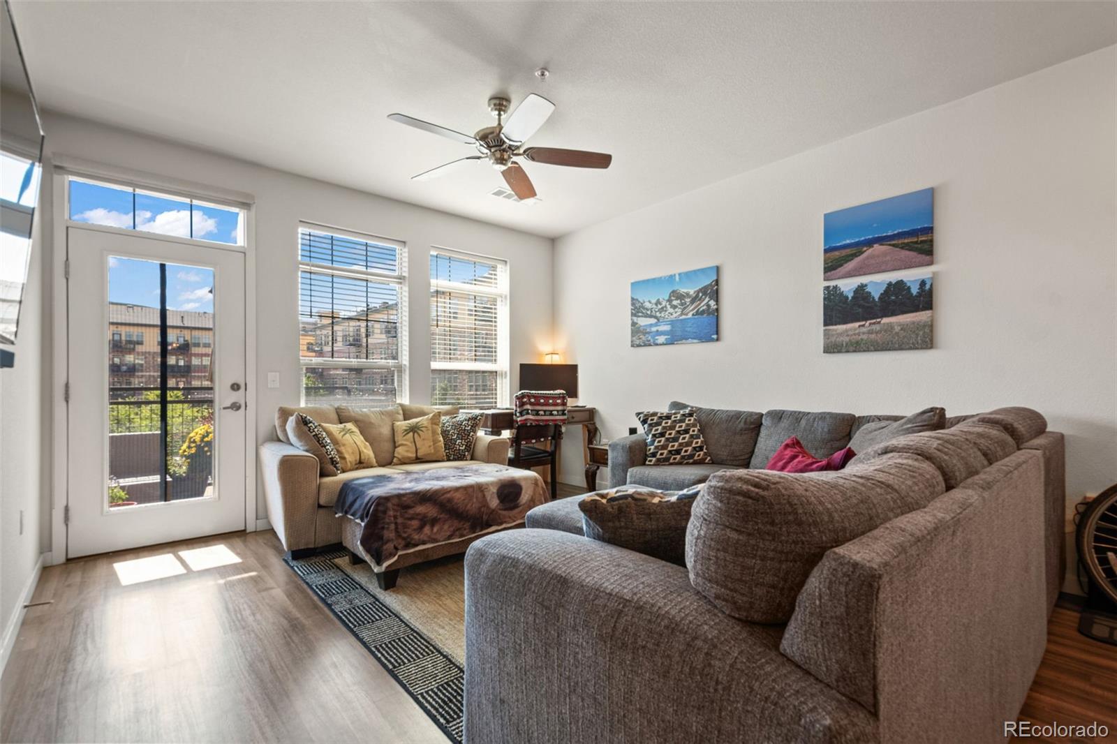 a living room with furniture and two large window