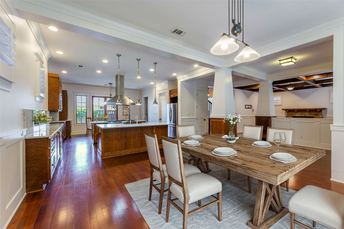 a view of a dining room and livingroom with furniture wooden floor a chandelier