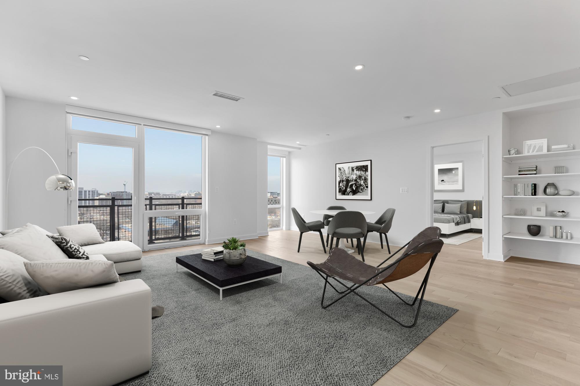 a living room with furniture a rug and a floor to ceiling window