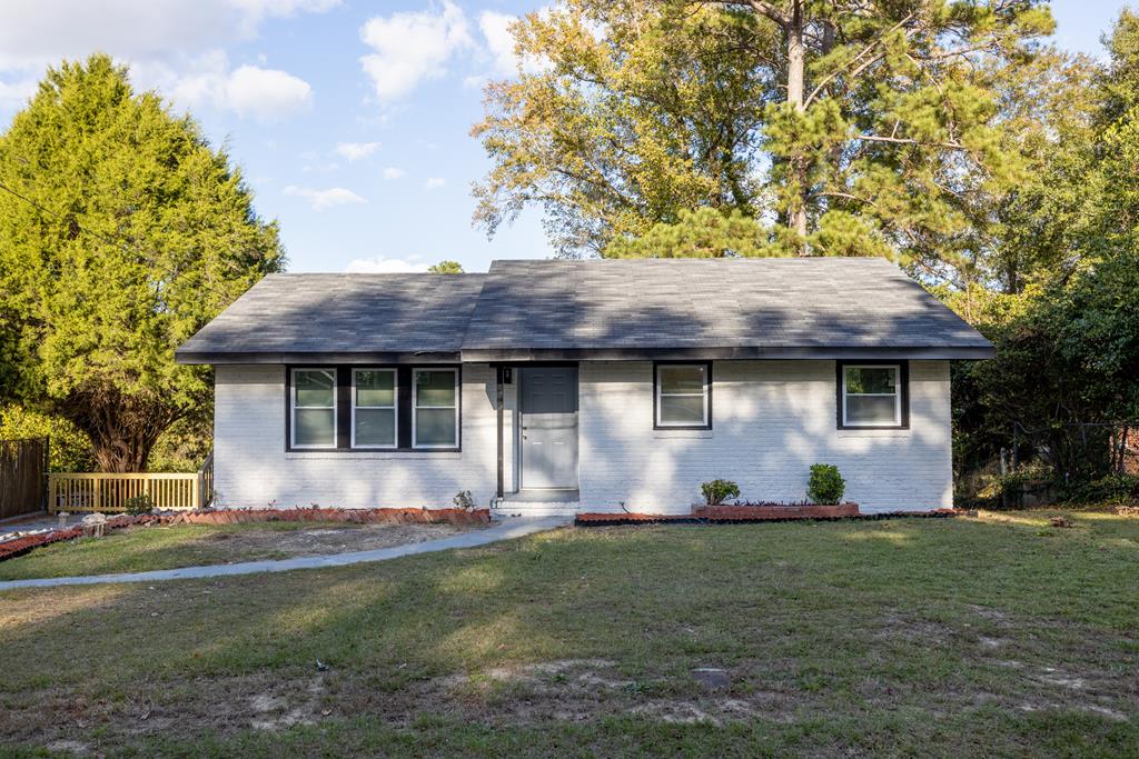 a front view of brick house with a yard