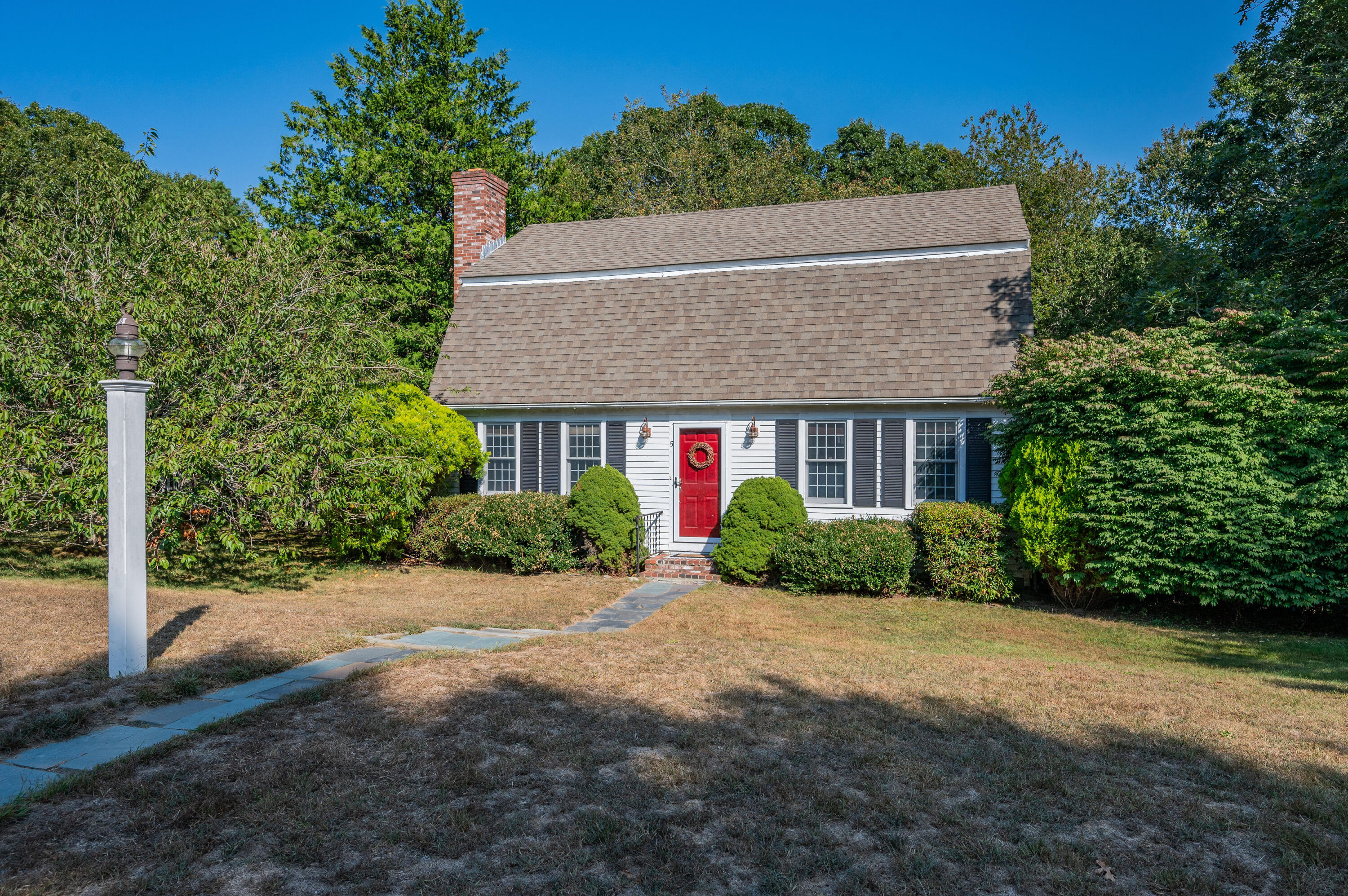 a front view of a house with a yard and potted plants