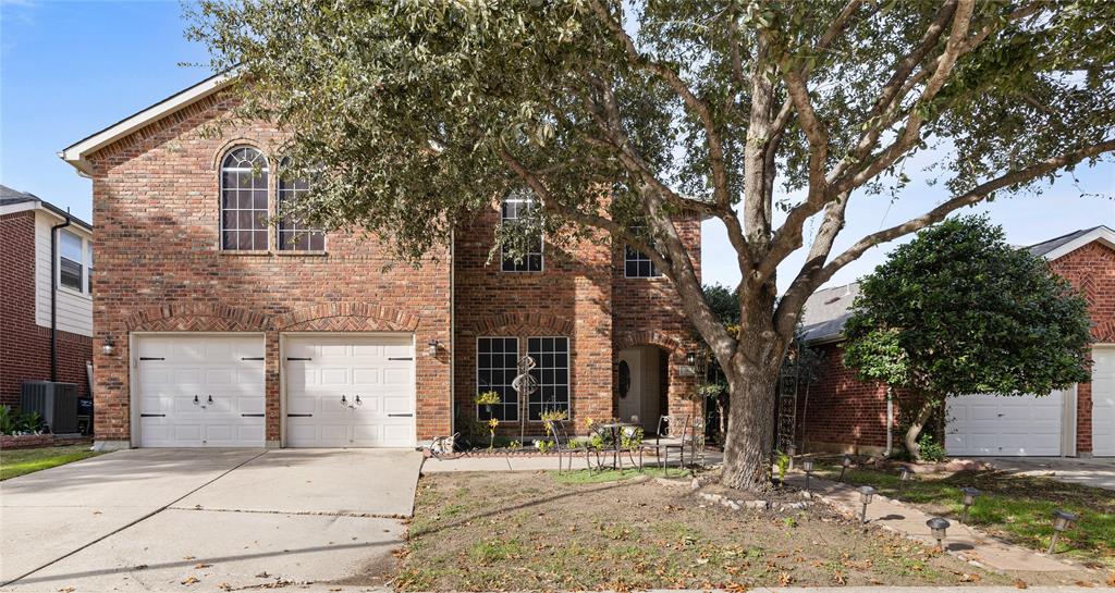 View of front of home featuring central AC unit and a garage