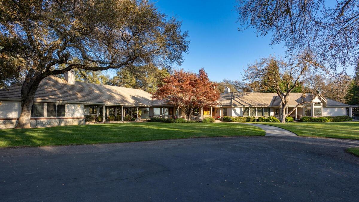 a front view of a house with a yard and trees