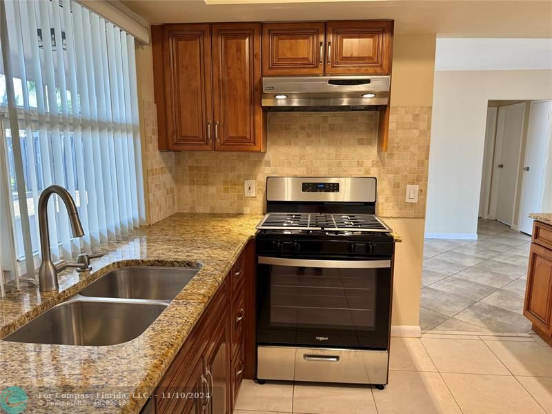 a kitchen with granite countertop a stove and a sink