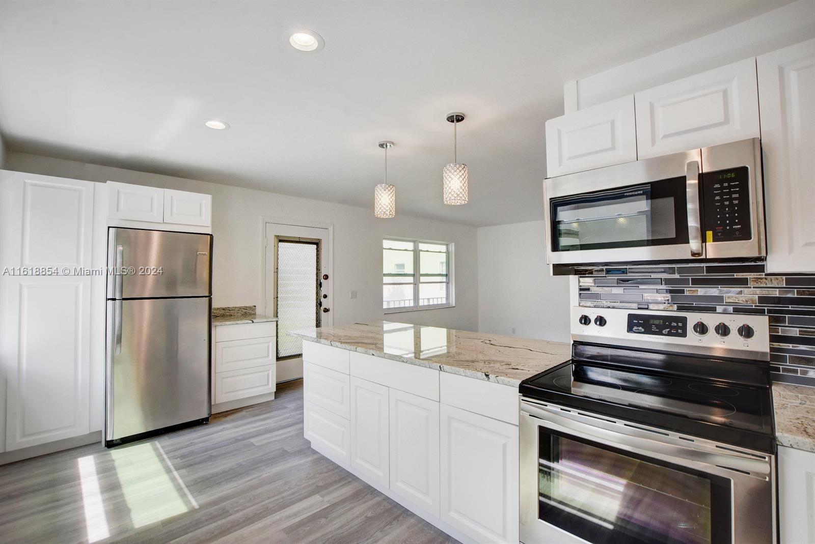 a kitchen with stainless steel appliances a stove microwave and refrigerator