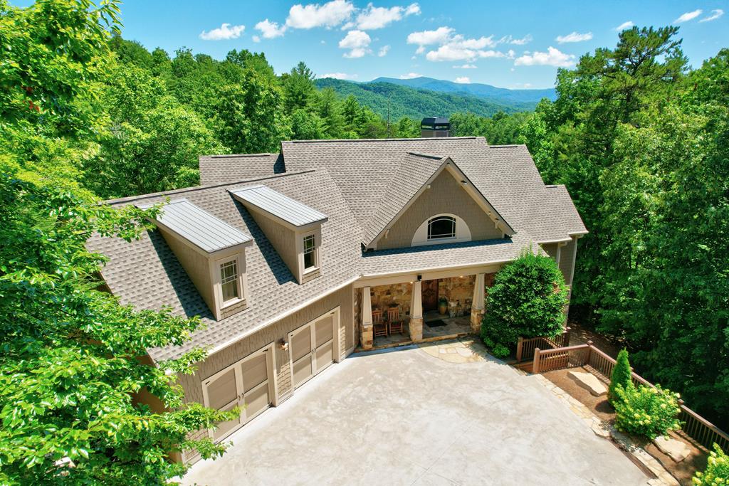 an aerial view of a house with a yard and large trees