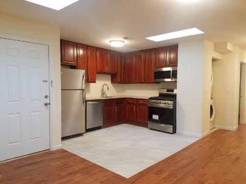 a kitchen with stainless steel appliances kitchen island granite countertop a refrigerator a sink and a stove