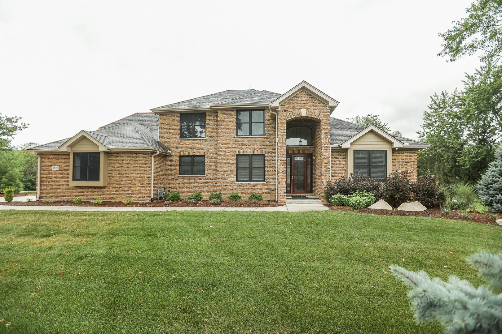 a front view of a house with a garden