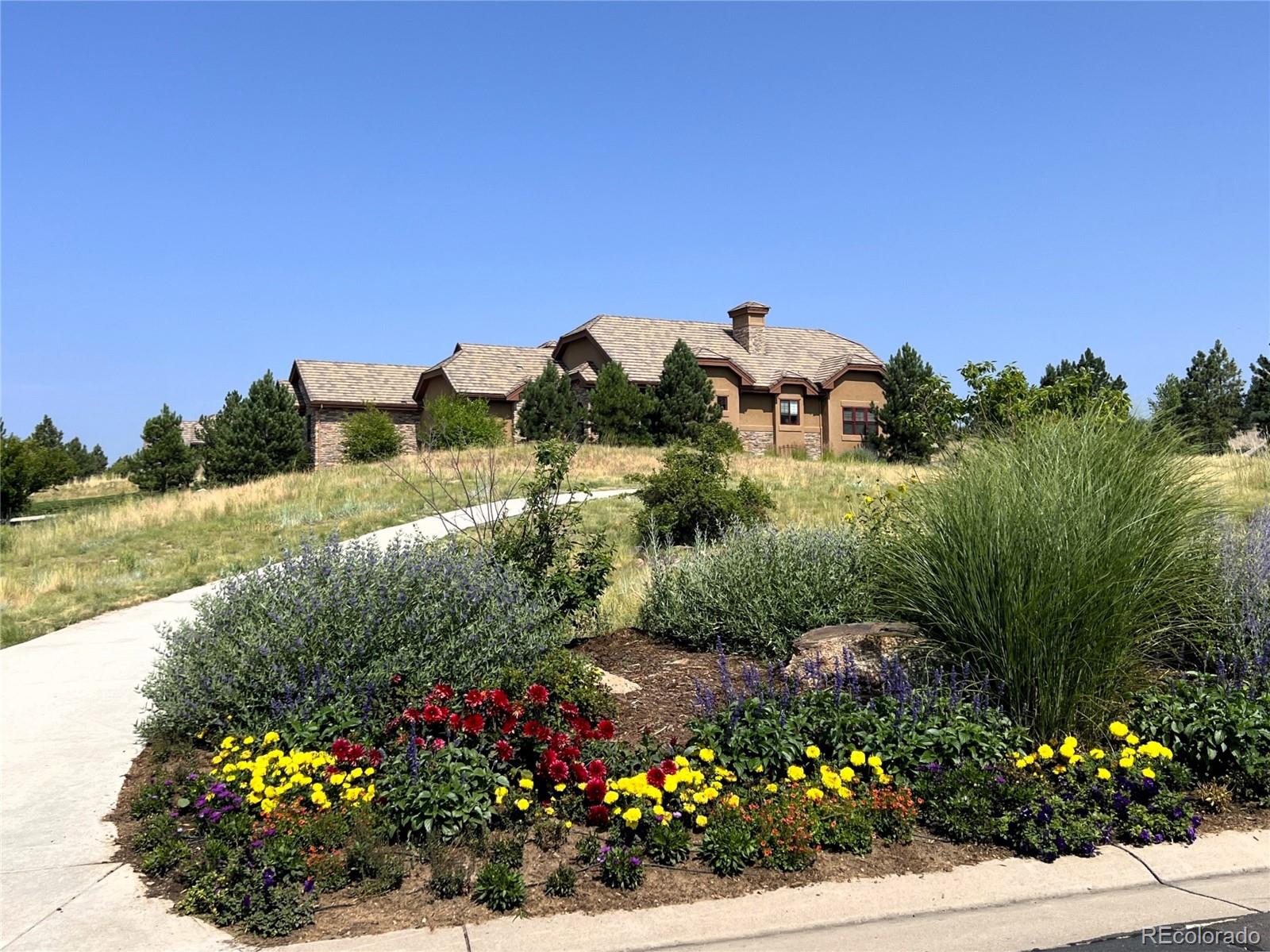 a view of a garden with a lot of flower plants and wooden fence