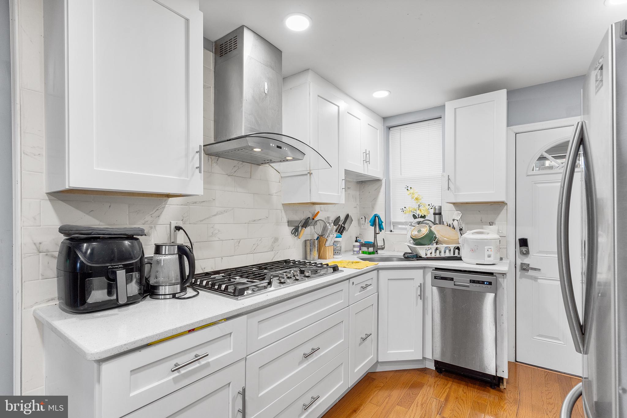 a kitchen with white cabinets and white appliances