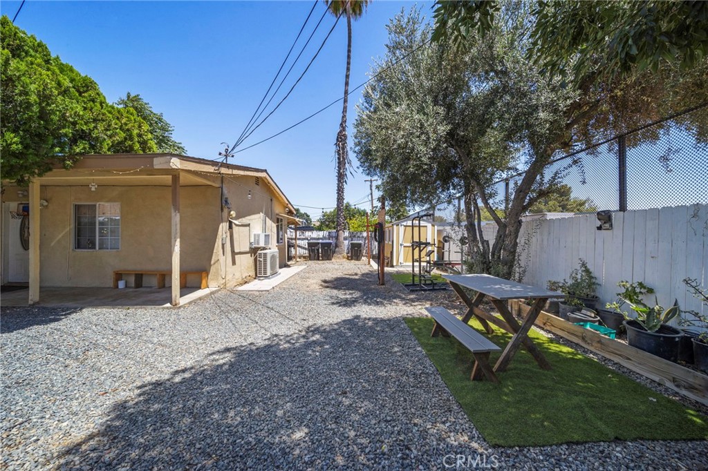 a view of a backyard with table and chairs and a large tree