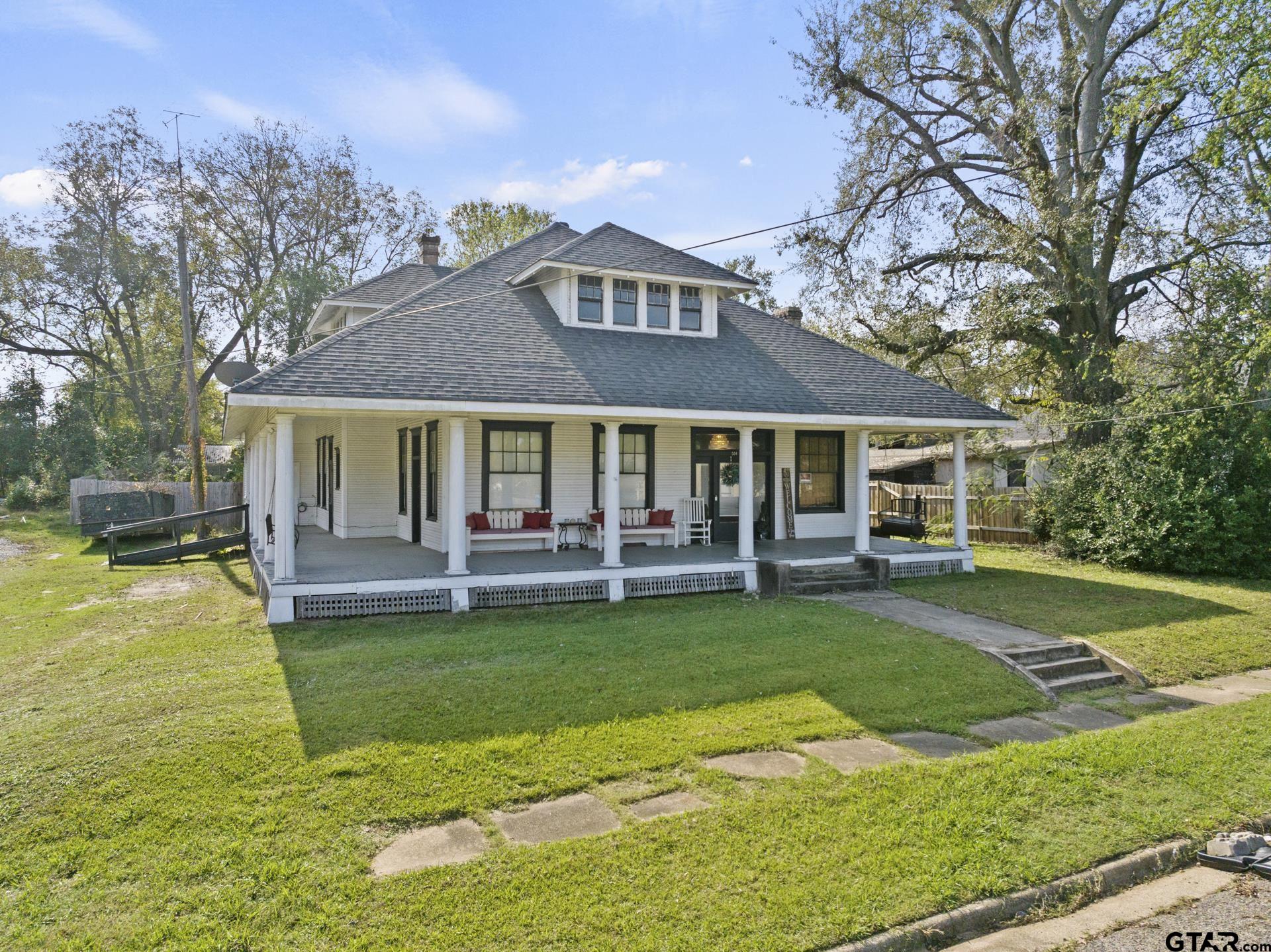 a front view of a house with a garden and swimming pool