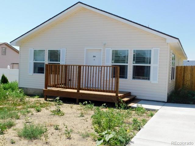 a view of a house with backyard and wooden fence