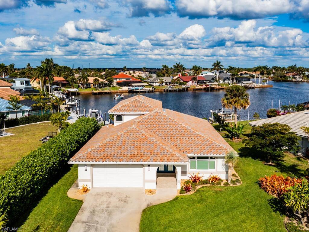 an aerial view of a house with a garden and lake view